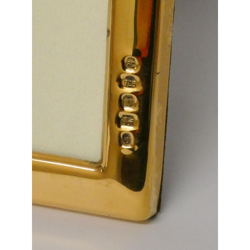 504 - A modern silver gilt rectangular easel photograph frame. 22cms tall