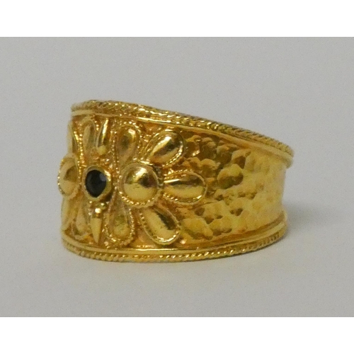 570 - A Greek yellow gold wide band Etruscan style ring, set with a sapphire, marked 585 for 14ct. Ring si... 