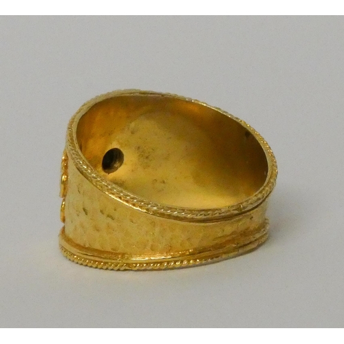 570 - A Greek yellow gold wide band Etruscan style ring, set with a sapphire, marked 585 for 14ct. Ring si... 