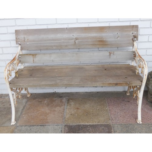 921 - A two seater garden bench with planked seat and back with decorative white painted ends