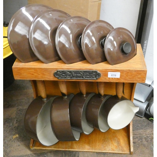 876 - A set of five brown graduating Le Creuset saucepans all with lids with a Le Creuset display type cab... 