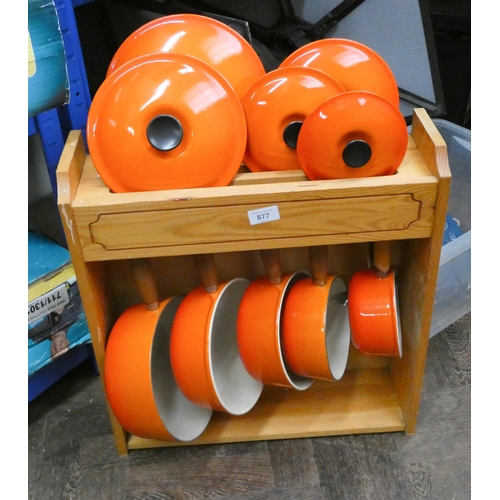 877 - A set of five orange graduating Le Creuset saucepans all with lids with a Le Creuset display type ca... 