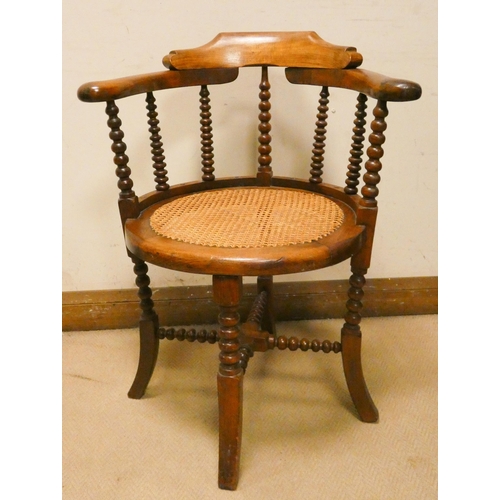 458 - A mahogany tub shaped desk chair with turned spindle back and cane seat