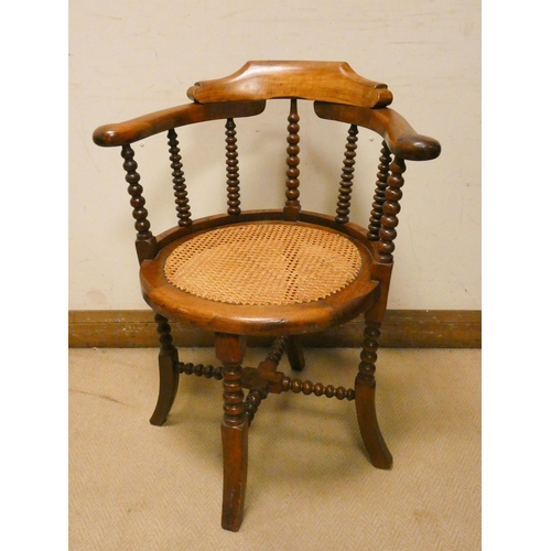 458 - A mahogany tub shaped desk chair with turned spindle back and cane seat