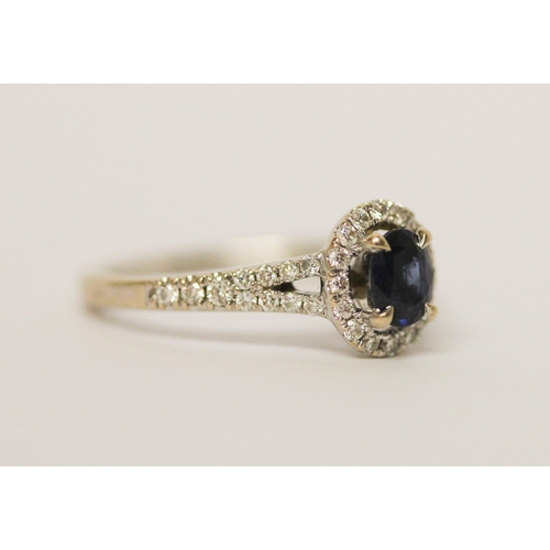 578 - Modern 18ct white gold sapphire and diamond oval cluster ring. Diamond weight 0.22 carats marked in ... 