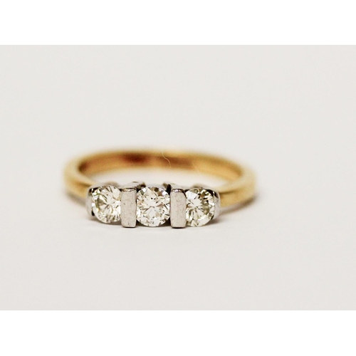 615 - A three stone diamond ring, on 18ct yellow band. Marked 750 Gross weight 3.7g, ring size L