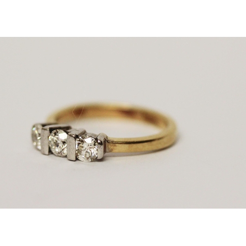 615 - A three stone diamond ring, on 18ct yellow band. Marked 750 Gross weight 3.7g, ring size L