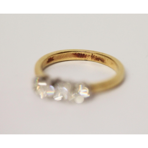 615 - A three stone diamond ring, on 18ct yellow band. Marked 750 Gross weight 3.7g, ring size L