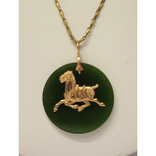 617 - A jade disc pendant with 14ct gold horse motif on plated chain