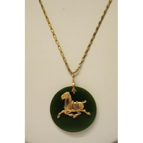 617 - A jade disc pendant with 14ct gold horse motif on plated chain