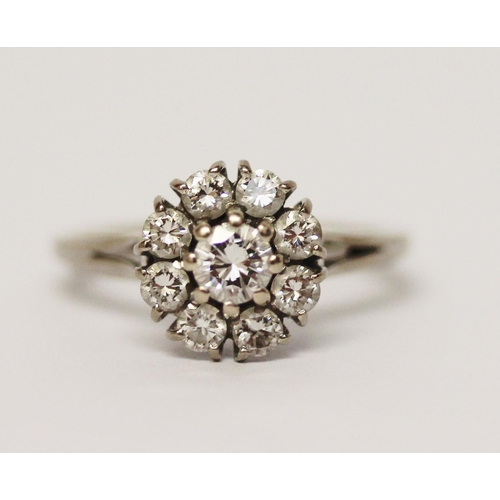 620 - A diamond circular cluster ring, on hallmarked 18ct white gold band. Ring size M