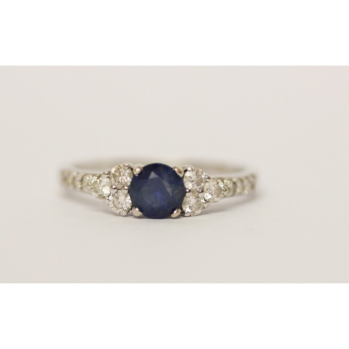 624 - A modern sapphire and diamond cluster ring, on 18ct white gold band. Marked 750 18K, ring size N