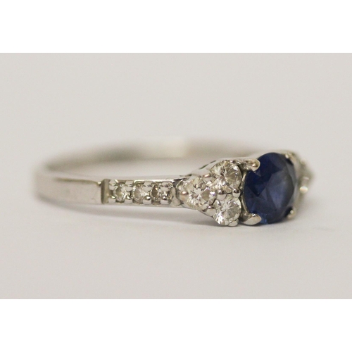 624 - A modern sapphire and diamond cluster ring, on 18ct white gold band. Marked 750 18K, ring size N