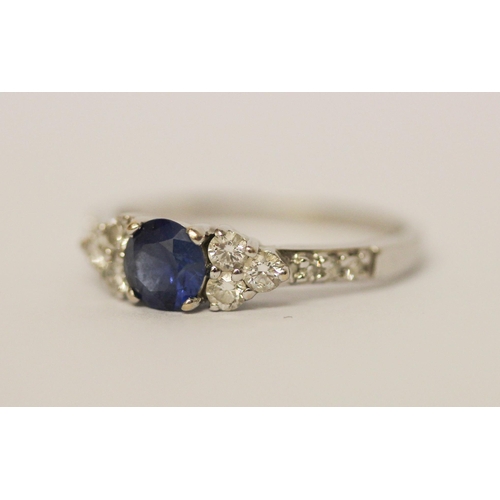 624 - A modern sapphire and diamond cluster ring, on 18ct white gold band. Marked 750 18K, ring size N