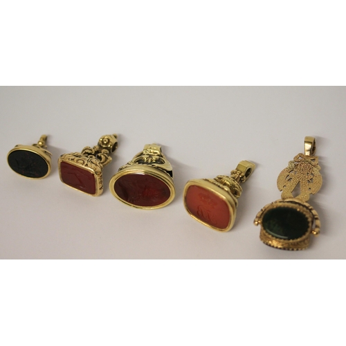 638 - A large triple stone set swivel fob and four 19th century carved intaglio panel fobs, all set in unm... 