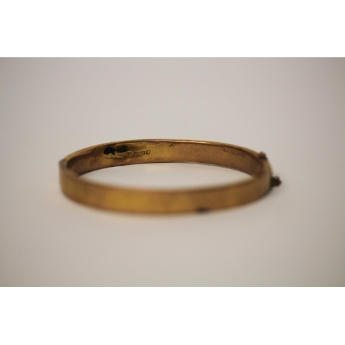 653 - 9ct yellow gold bangle with invisible clasp and safety chain. Weight 8.2 grams