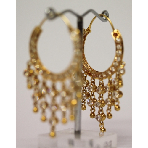 656 - A pair of Indian yellow gold tasselled creole hoop earrings, set with white stones. Gross weight 13.... 