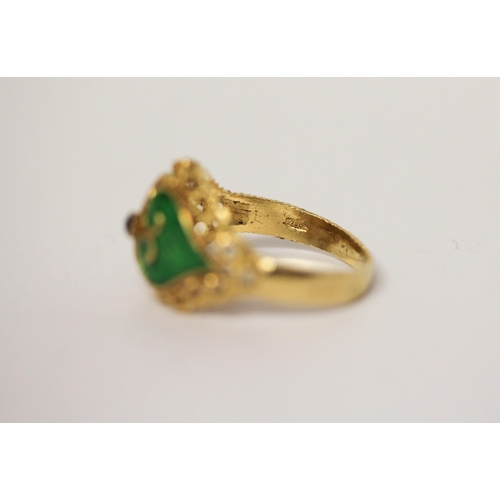 657 - Indian yellow gold dress ring with green enamel decoration, shank marked 750. Ring size M