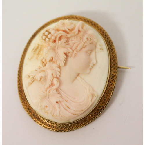 659 - An antique carved coral cameo brooch, carved with a bacchante in granulated yellow gold mount, tests... 