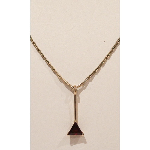 672 - 9ct gold garnet set triangular pendant on 9ct gold chain, gross weight 6.1gms