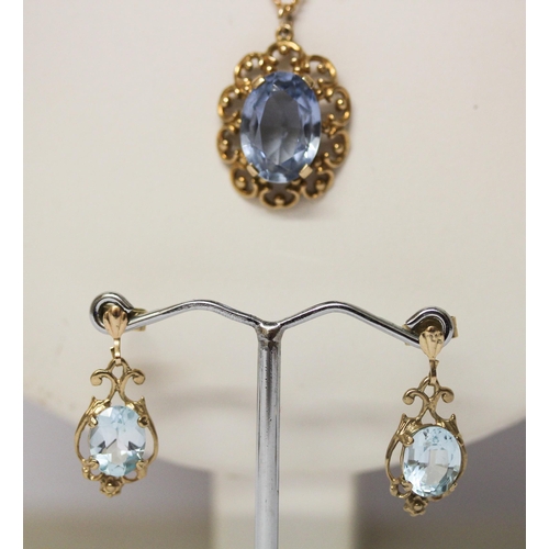 674 - 9ct gold blue topaz pedant on chain and a pair of matching drop earrings