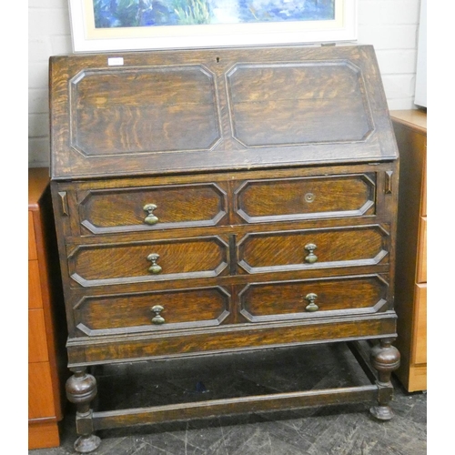 184 - A 1930's Jacobean style oak bureau with slide out interior with three long drawers under on bulbous ... 