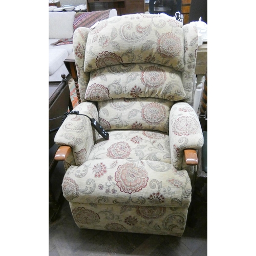 218 - An HSL electric rise and recline easy chair in fawn patterned covering