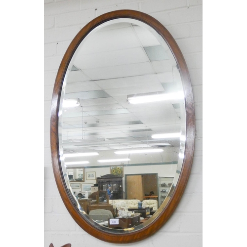 240 - A very large oval bevelled wall mirror in an inlaid mahogany frame