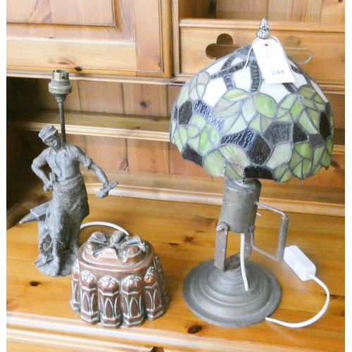 244 - A brass and Tiffany style table lamp, a blacksmith figure table lamp and an old copper jelly mould