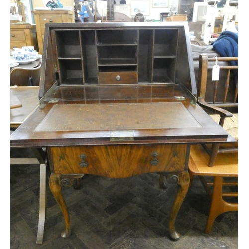 131 - A ladies walnut writing bureau with two drawers under standing on cabriole legs, 2' wide