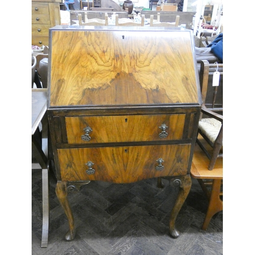 131 - A ladies walnut writing bureau with two drawers under standing on cabriole legs, 2' wide