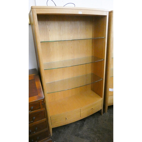 265 - A modern bow front light oak open bookcase/display cabinet with glass shelves and two drawers under ... 