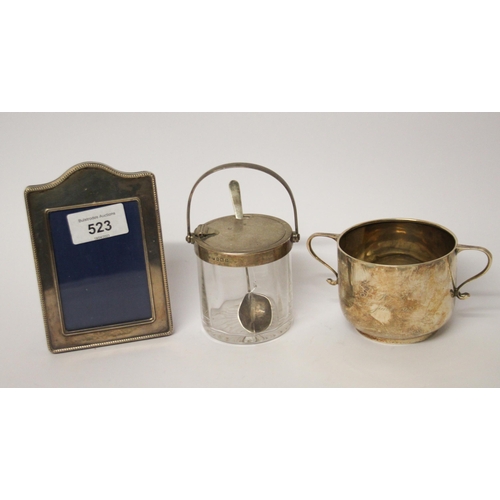 523 - A small silver photograph frame, a silver sugar basin and a Asprey silver topped patented preserve j... 