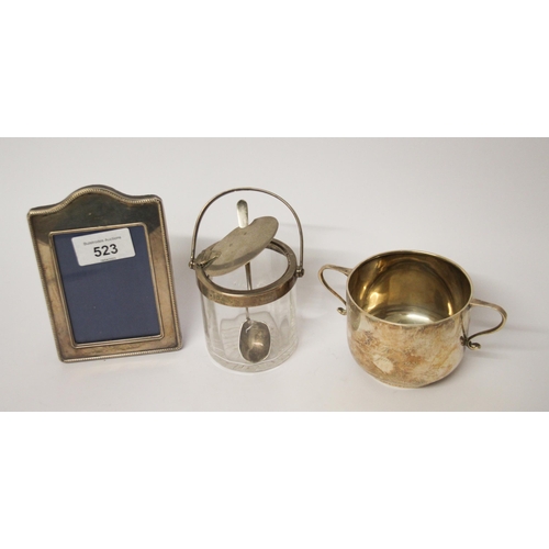 523 - A small silver photograph frame, a silver sugar basin and a Asprey silver topped patented preserve j... 