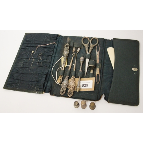 529 - A Victorian sewing necessaire, in a leather wallet, containing various silver topped sewing implemen... 