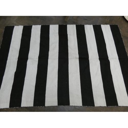 180 - A black and white striped design Kilim style wool pile rug, 7'7 X 5'1 approximately