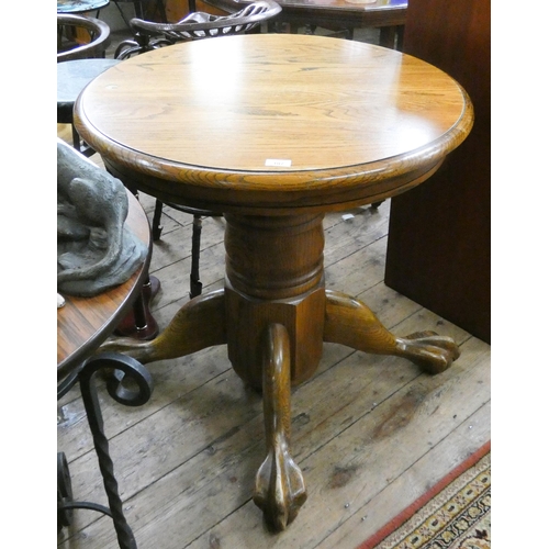 107 - A circular oak table on heavy pillar and foot stand, 2'6 diameter