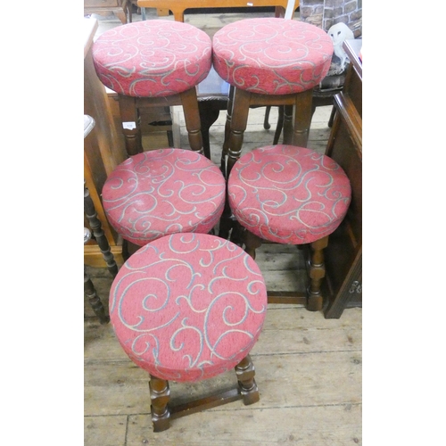 136 - A pair of tall oak framed bar stools with red upholstered seats and three smaller matching stools