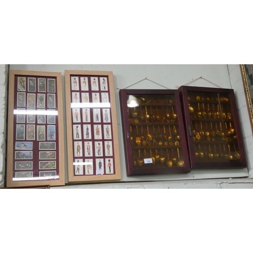 146 - Two wall cabinets full of commemorative spoons and two framed cigarette cards