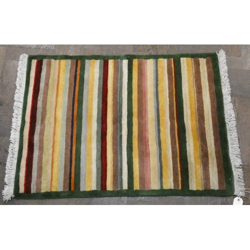 149 - A red and patterned Afghan style wool pile rug and a striped wool pile rug