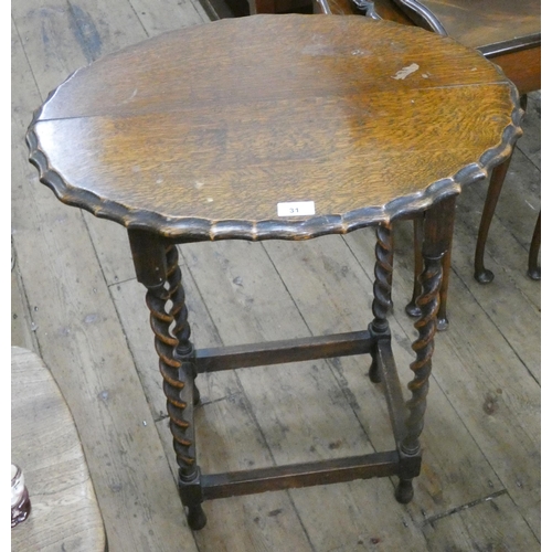 31 - An oval oak occasional table with pie crust edge standing on barley twist legs