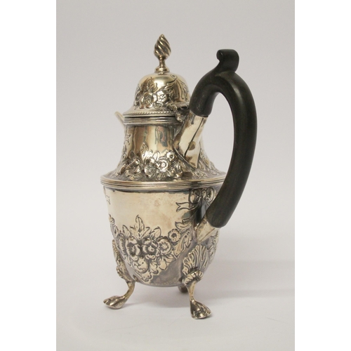 541 - A café au lait jug, with engraved and embossed floral swag decoration, on three paw feet. 14 cms tal... 