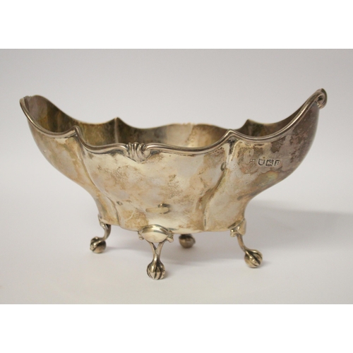 549 - A silver shaped sweetmeat basket, standing of four ball and claw feet. London 1910. 18cms across, 5.... 