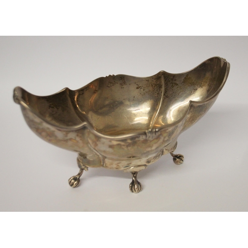 549 - A silver shaped sweetmeat basket, standing of four ball and claw feet. London 1910. 18cms across, 5.... 