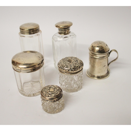 550 - A silver pepperette and a collection of silver topped dressing table jars.