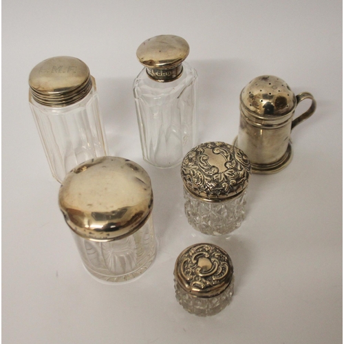 550 - A silver pepperette and a collection of silver topped dressing table jars.