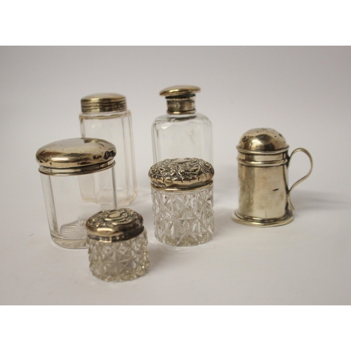 550 - A silver pepperette and a collection of silver topped dressing table jars.