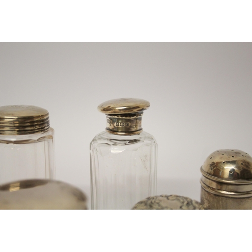 550 - A silver pepperette and a collection of silver topped dressing table jars.