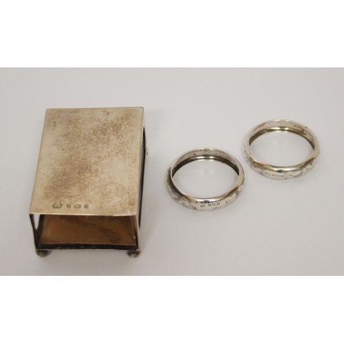 557 - A silver matchbox holder and a pair of silver napkin rings.