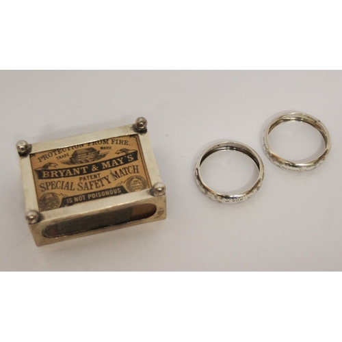 557 - A silver matchbox holder and a pair of silver napkin rings.